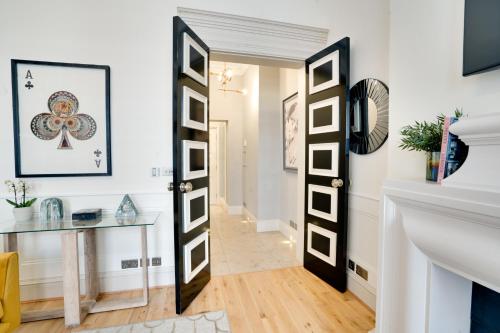 a hallway with a black and white door and a table at Designer Retreat by Green Park in London