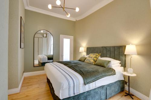 a bedroom with a large bed and a mirror at Designer Retreat by Green Park in London