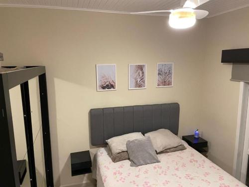 chalé charmoso - Mairinque في مايرينك: غرفة نوم بسرير وصور على الحائط