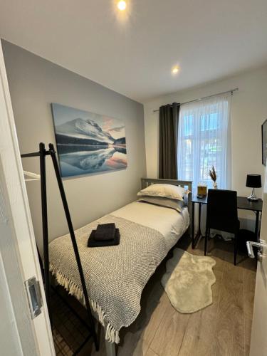 a bedroom with a bed and a desk and a window at Gorgeous Budget Room in Beckenham