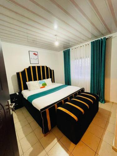 um quarto com uma cama grande e um sofá em Mancave em Eldoret