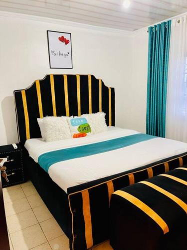um quarto com uma cama com uma cabeceira listrada em Mancave em Eldoret