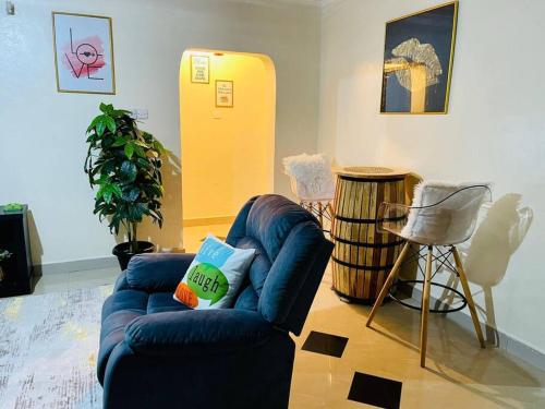 uma sala de estar com um sofá azul e uma cadeira em Mancave em Eldoret