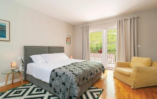 a bedroom with a bed and a chair and a window at House with pool Garden in Žrnovnica