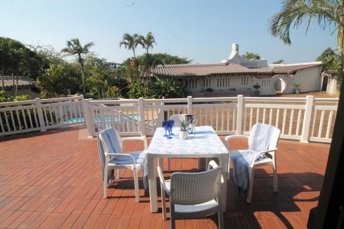 Una mesa blanca y sillas en un patio. en Summer Lodge Villa 2, en Uvongo Beach