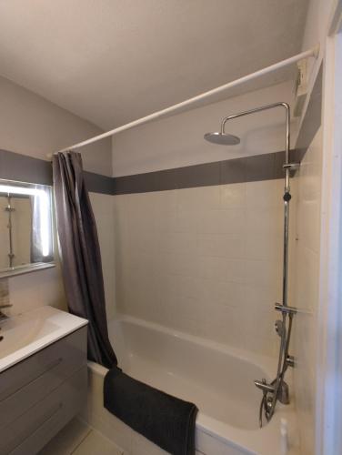 une salle de bain avec une baignoire, un lavabo et une douche dans l'établissement T3 Bonnefoy, à Toulouse