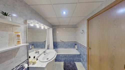 W łazience znajduje się umywalka i wanna. w obiekcie Apartamento vistas al mar, segunda línea 3 habitaciones w mieście Sant Carles de la Ràpita