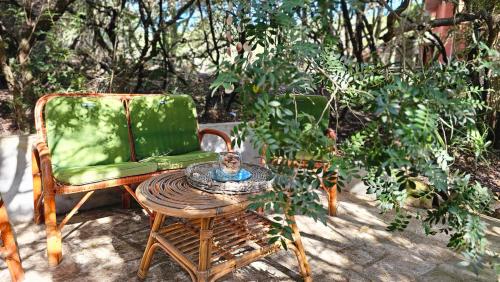 a green chair and a table and a chair and a table sidx sidx sidx at Sardinian Seaside Retreats in Badesi