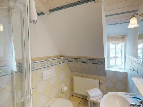 a bathroom with a toilet and a shower and a sink at Friesenhof, Haus Hafis Wohnung 8 in Nebel