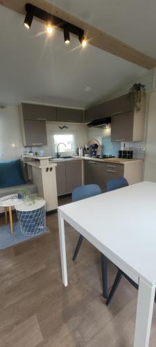 uma cozinha com uma mesa branca num quarto em Chalet Sea-renity Lakeside met jacuzzi em Jabbeke