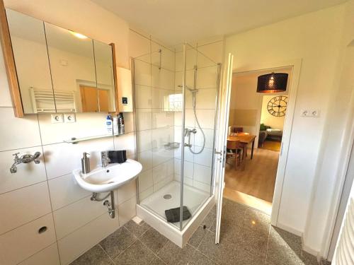 a bathroom with a sink and a glass shower at Akram Appartement IV - Nähe Bahnhof in Hildesheim