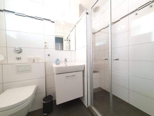 ein weißes Bad mit einem WC und einem Waschbecken in der Unterkunft Erholung Pur in Hahnenklee-Bockswiese