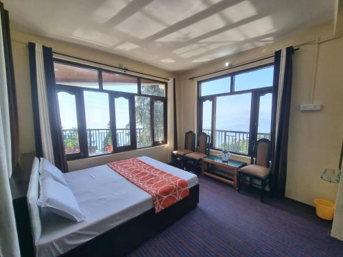 a hotel room with a bed and large windows at Jungle Stay Dalhousie(Kalatop) in Dalhousie