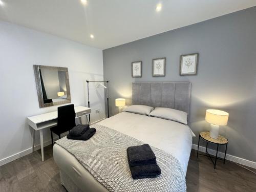 een slaapkamer met een bed, een bureau en een spiegel bij Exquisite Double Room in Beckenham