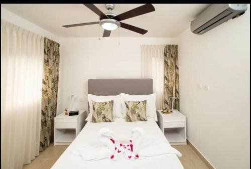 a bedroom with a white bed with a ceiling fan at Cristamar Condominium "Cozy Oasis, Adorable" in Cabarete