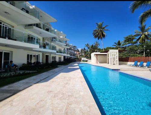 a swimming pool in front of a building at Cristamar Condominium "Cozy Oasis, Adorable" in Cabarete