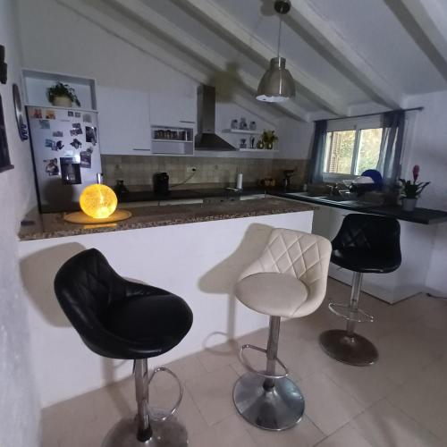 - une cuisine avec 2 chaises de bar et un comptoir dans l'établissement Maison bord de mer, à Penta-di-Casinca