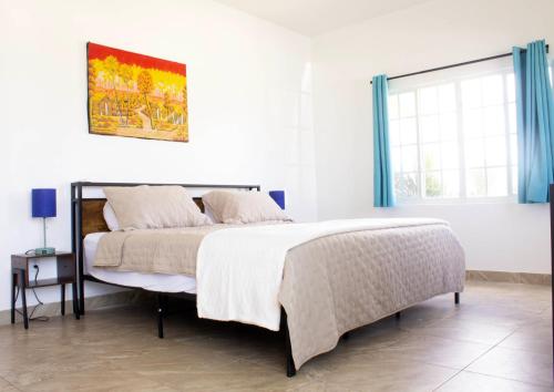 a white bedroom with a bed and a window at The Sunflower Villa in Grand Turk