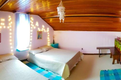 una camera da letto con due letti e soffitto in legno di Cantinho da Siriema - Sua fuga de diversão na Natureza a 55km de BH a Antônio dos Santos
