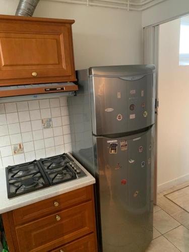 - une cuisine avec un réfrigérateur en acier inoxydable à côté d'une cuisinière dans l'établissement 3 Rooms Parisian apartment, à Paris