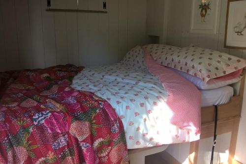 a bedroom with a bed with a comforter on it at Duck Hut in Dundon