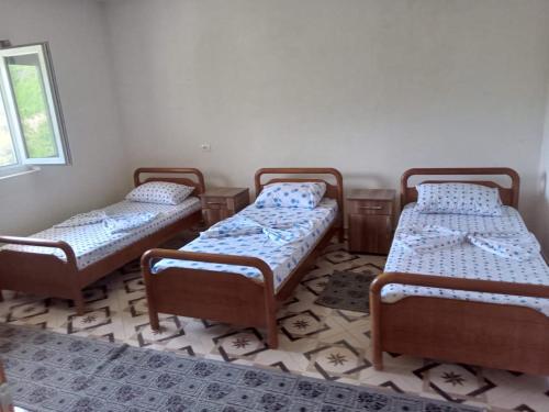 3 camas en una habitación con suelo en Bujtina Aliaj en Tropojë