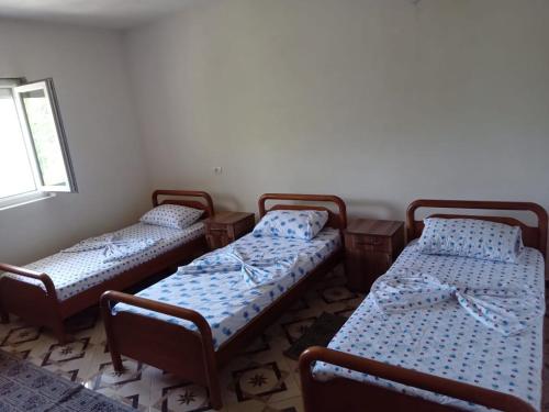 a group of three beds in a room at Bujtina Aliaj in Tropojë