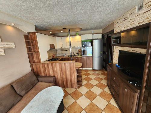 sala de estar con TV y cocina en Przy Wydmie, en Mrzeżyno
