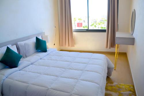 a large white bed in a room with a window at Palm D'or-Appartement familial de luxe au centre de Dakhla in Dakhla