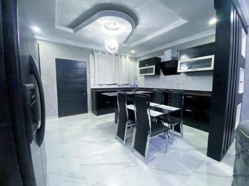 a kitchen with a black table and black chairs at IRISH Apartment in Kasoa