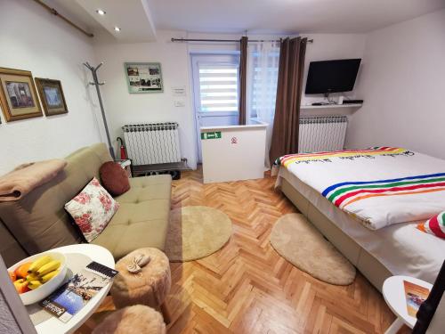 un salon avec un lit et un canapé dans l'établissement Apartment Miris Dunja, à Sarajevo