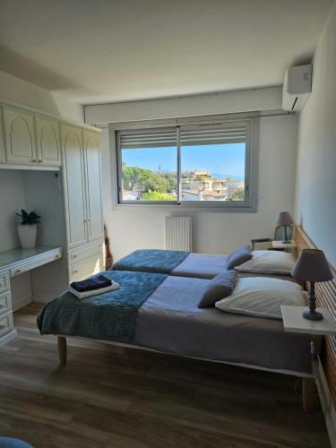 um quarto com uma cama grande e uma janela em Les Sables - 75 m2 - 4 stars tourism Panoramic View em Antibes