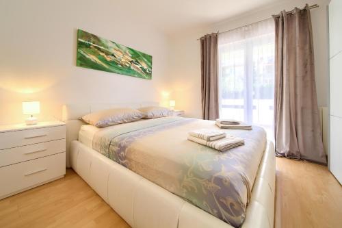 a bedroom with a bed with towels on it at Apartmani ASSA Krk in Krk