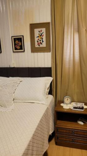 a bedroom with a bed and a table with a night stand at Casa da Vó Hospedagem Afetiva in Bento Gonçalves