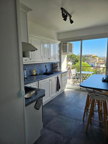 une cuisine avec des placards blancs et une table avec vue dans l'établissement Les Sables - 75 m2 - 4 stars tourism Panoramic View, à Antibes