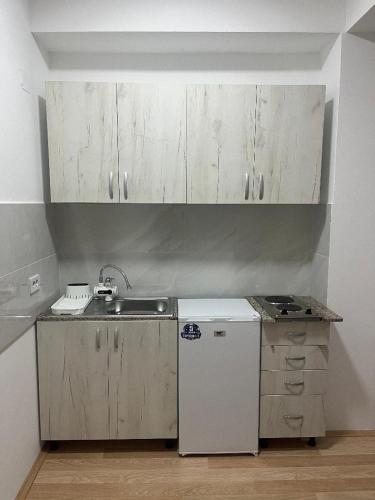 a kitchen with white cabinets and a sink at Studio MERAKI in Star Dojran