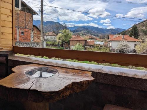 a table on a balcony with a view of a city at Kovacha Guest House in Raduil
