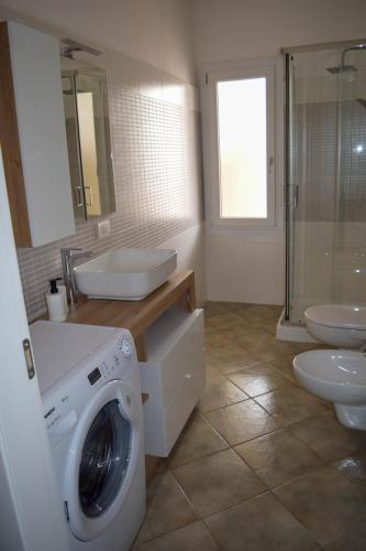 a bathroom with a washing machine and a washer at Residenza il Filo in Orosei