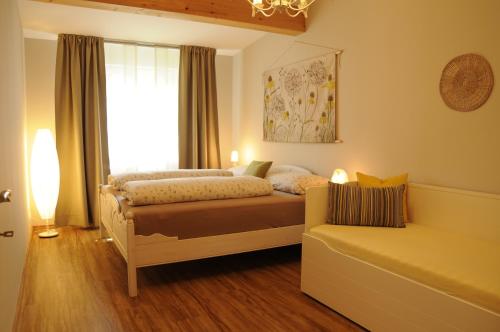 ein Schlafzimmer mit einem Bett, einem Fenster und einem Sofa in der Unterkunft das stille Paradies in Ledenitzen