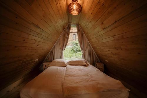 コリビツァにあるCasuta Carmen A Frameの窓付きの木造の部屋のベッド1台