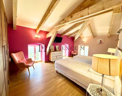 - une chambre aux murs roses avec un lit et une chaise dans l'établissement Maison golf de calvi couchers de soleil vue mer LUMIO, à Lumio