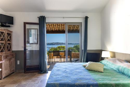 Schlafzimmer mit einem Bett und Meerblick in der Unterkunft Résidence U Paviddonu in Porto-Vecchio