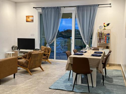 a dining room with a table with chairs and a television at The Sunflower Villa in Grand Turk