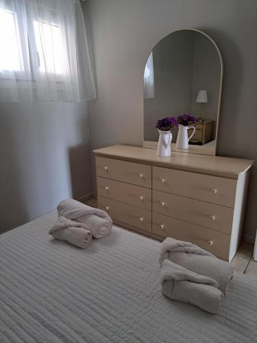 a bedroom with a bed with a dresser and a mirror at Kiki's Place in Nikiti
