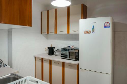 a kitchen with a white refrigerator and a microwave at Mieszkanie Słoneczny Sandomierz in Sandomierz