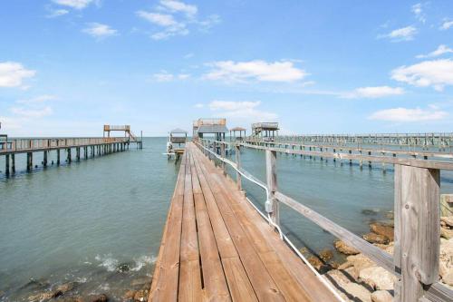 a wooden pier in the middle of the water at High Hopes on the bay! in San Leon