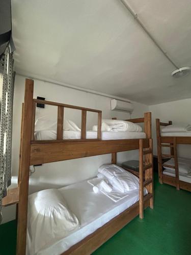 2 Etagenbetten in einem Zimmer mit grünem Boden in der Unterkunft The Bridge Hostel in Berat