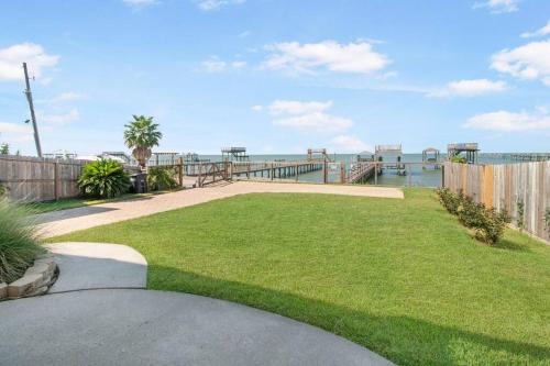 a grassy yard with a view of the water at High Hopes on the bay! in San Leon