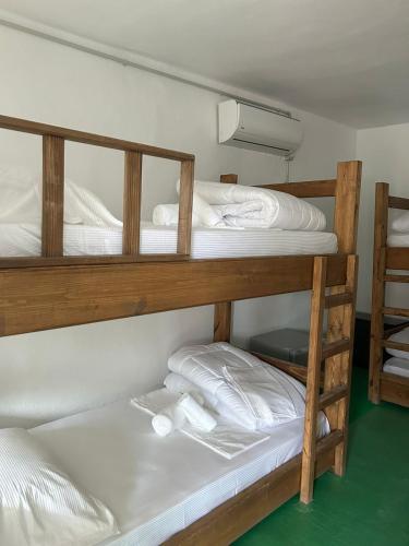 2 Etagenbetten in einem Zimmer mit grünem Boden in der Unterkunft The Bridge Hostel in Berat