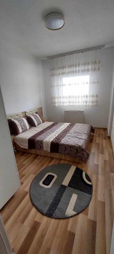 1 dormitorio con 1 cama grande y 1 alfombra en ARIA, en Kosovska Mitrovica